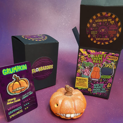 Halloween-themed product packaging with a small pumpkin decoration on a purple surface