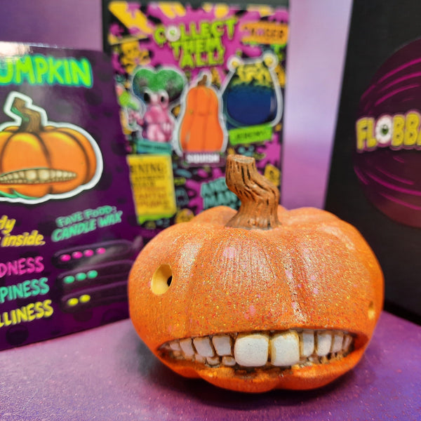 Pumpkin with a face and teeth, surrounded by colorful boxes with text and branding.
