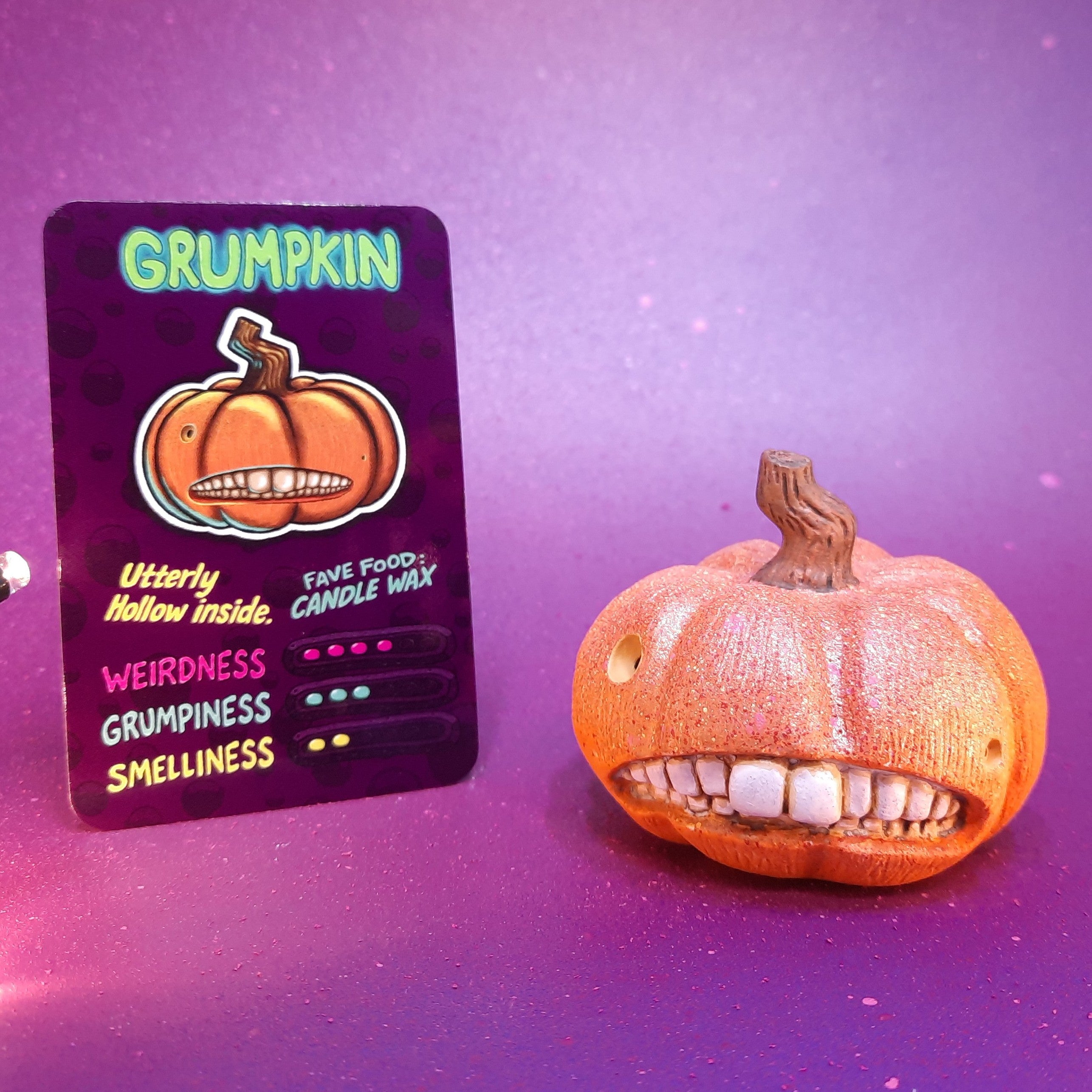 Grumpkin pumpkin-headed Flobbazoid figurine with visible teeth and specimen card.