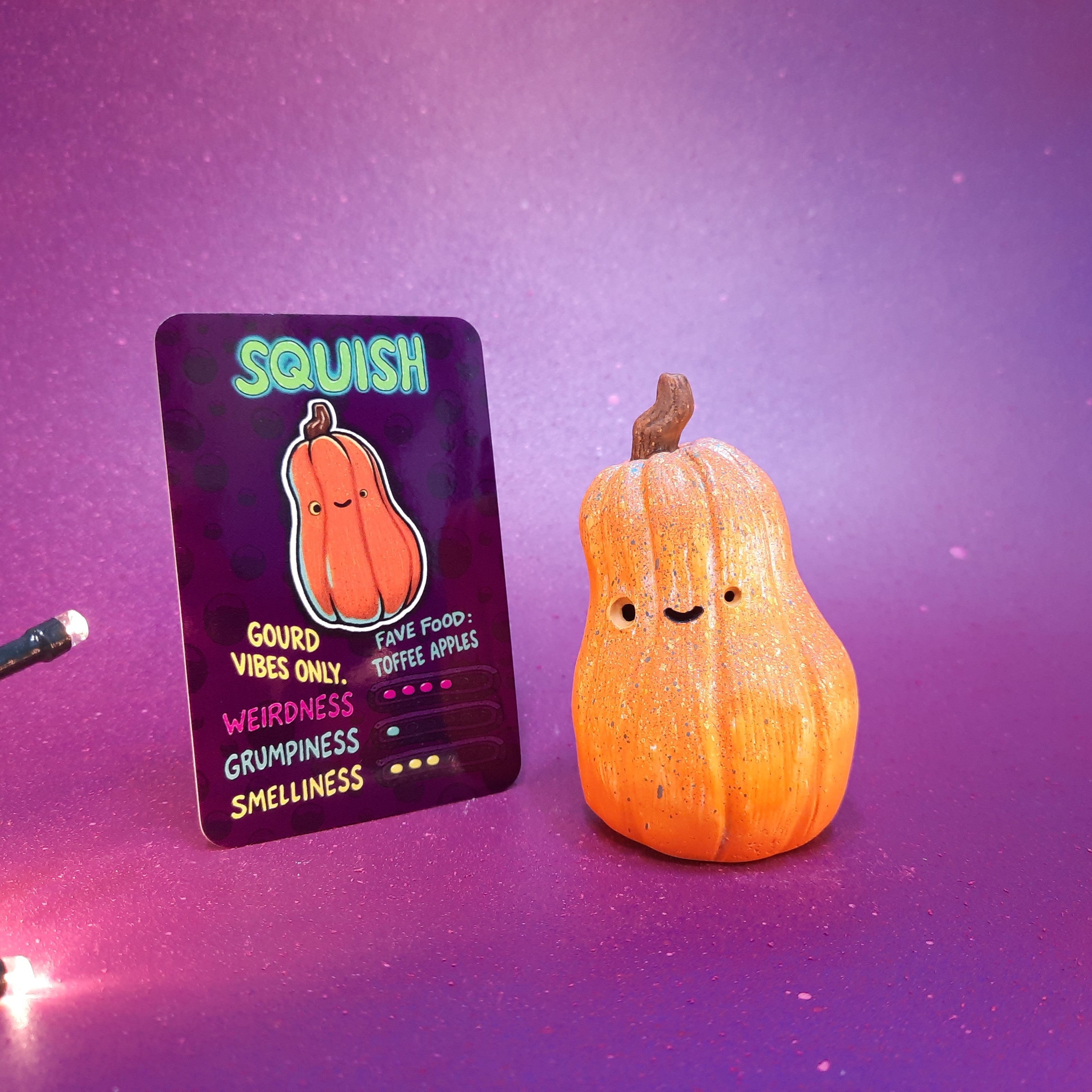 Squish gourd toy with a card on a purple gradient background