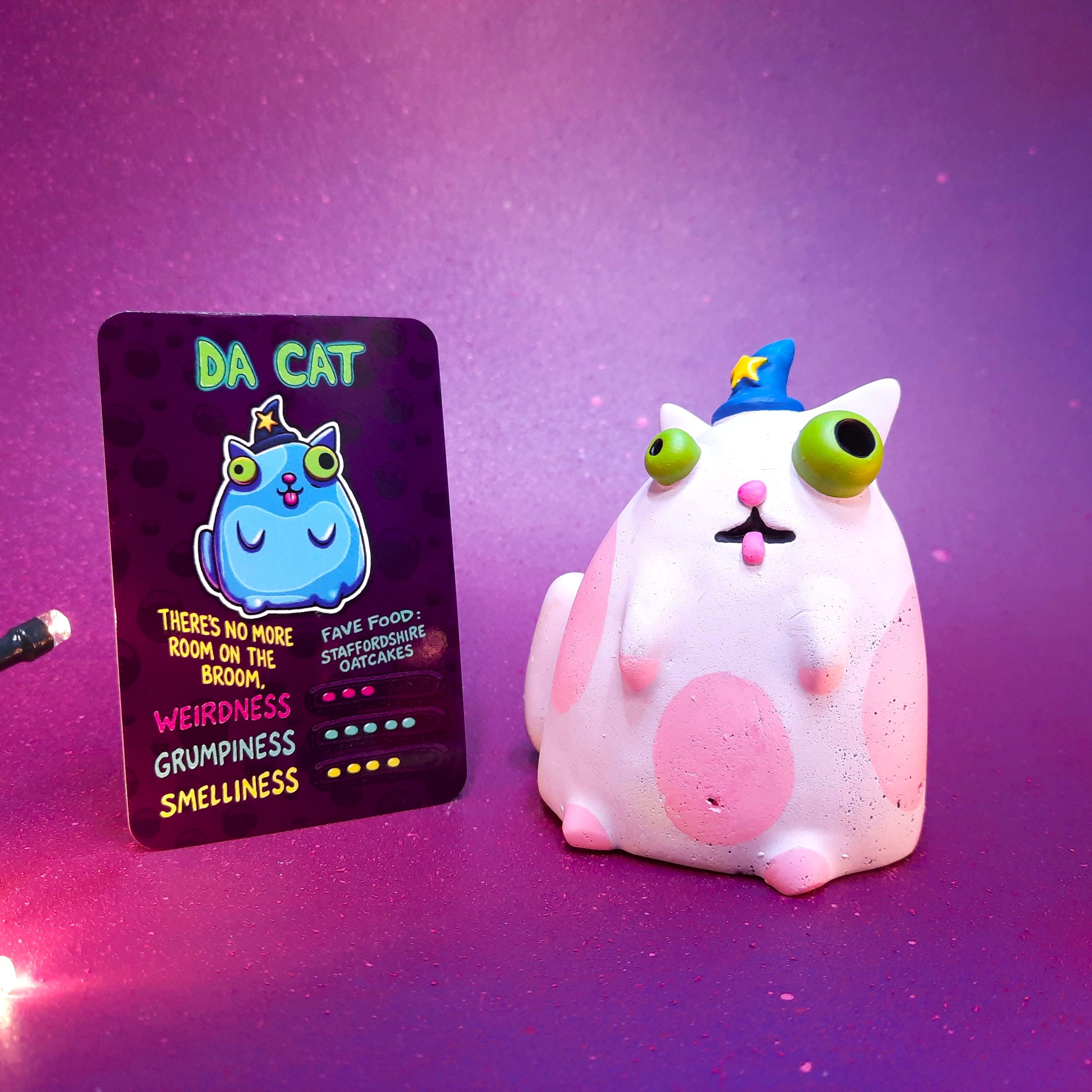 Cute cat figurine with a matching card on a purple background